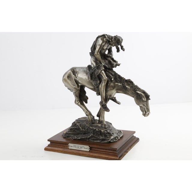 Cast in rich patinated metal (pewter/cold-cast bronze finish), the sculpture captures the exhaustion and quiet resilience...