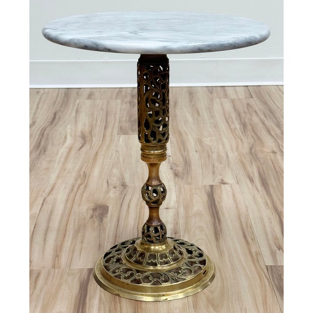 Classic vintage French style brass filigree base table with round marble top. Marble features nice veining. Versatile...