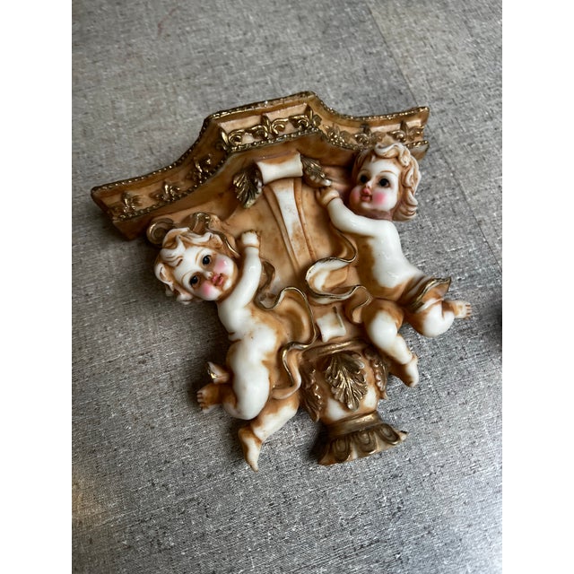 Up for consideration is a beautiful vintage pair of cherub resin wall brackets/sconces with gold accents. These would look...