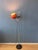 Mid-century orange "space age" floor lamp featuring a striking eyeball shade. The lamp is designed with flexibility in...