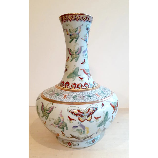 Chinese Porcelain butterfly changjingping, a long necked vase with a gold glazed lip, and a white glazed exterior,...