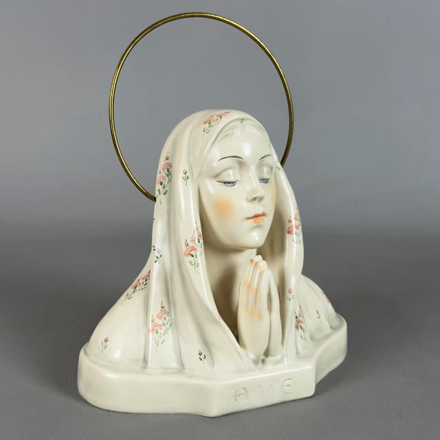 An evocative devotional bust depicting the virgin mary in prayer, an original glazed ceramic sculpture signed by the...