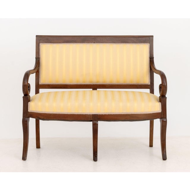 Louis Philippe Style Upholstered Mahogany Settee, with cream and golden striped silk and cotton upholstery, scroll form...