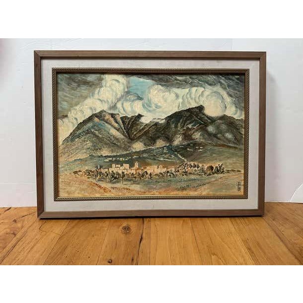 This Mid-Century oil painting depicts, mountains, voluminous clouds and a small village. The mountains and clouds have a...