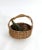 Rustic hand-made woven wicker and grapevine basket with freeform handle.