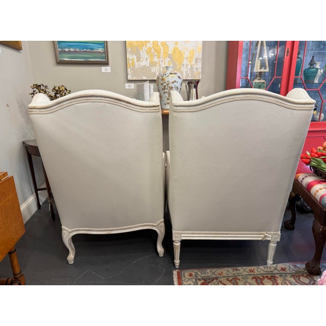 This is a pair of vintage French Louis XVI Mr. and Mrs. wingback chairs. They have been newly reupholstered with a linen...