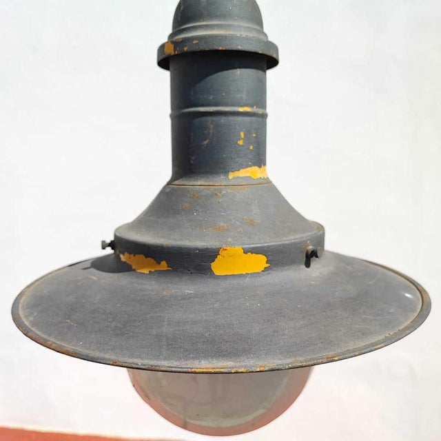 Industrial metal and glass chandelier Height: 55 Width: 40 This piece is attributed to the mentioned designer/maker. It...