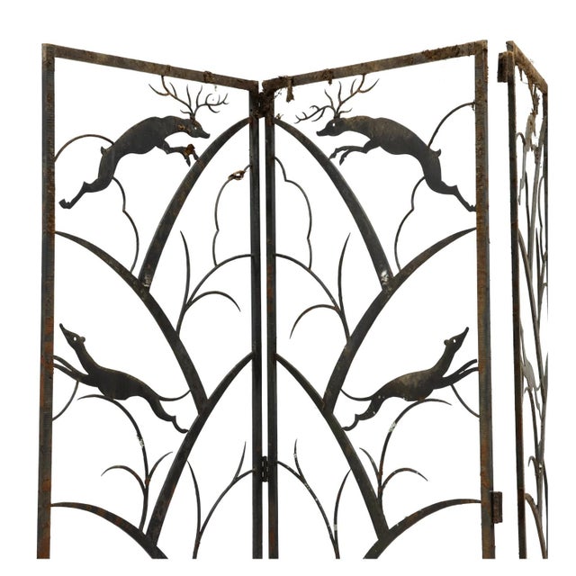 Circa 1930, black painted iron, four wrought iron panels with stag and hunting hound motifs, chiseled surface highlights...