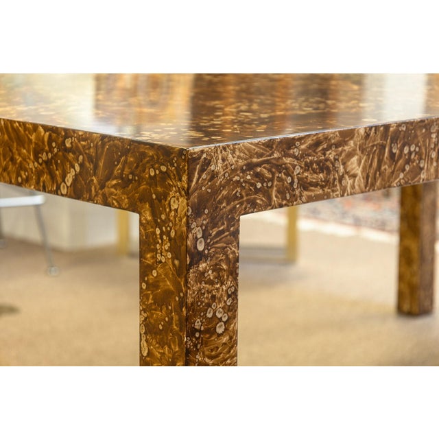 A vintage 1970s burlwood laminate parsons dining table. This super 1970s dining table features a gorgeous, modern parsons...