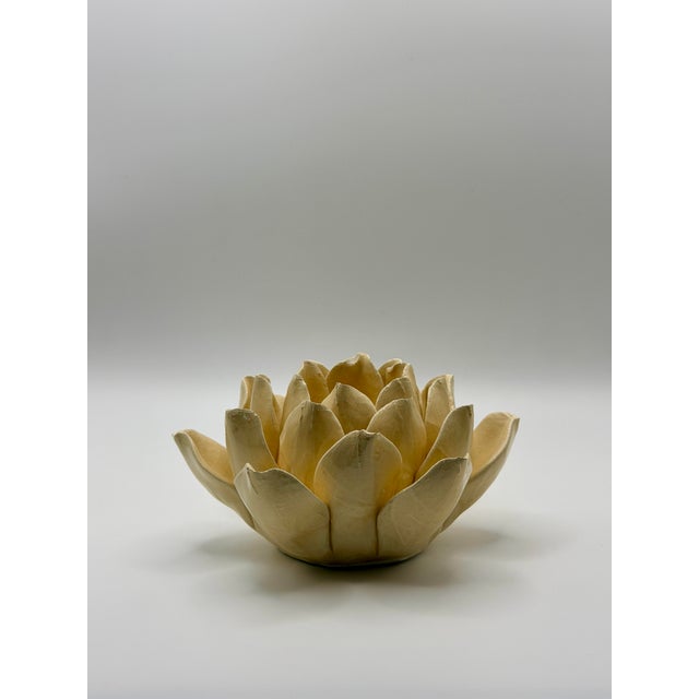 Handcrafted ceramic lotus flower candle holder featuring layered sculpted petals in a warm cream glaze. Designed to hold a...