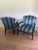 Upholstered chairs in green and blue cabana stripe fabric, finished with brass nailhead details on a black lacquered...