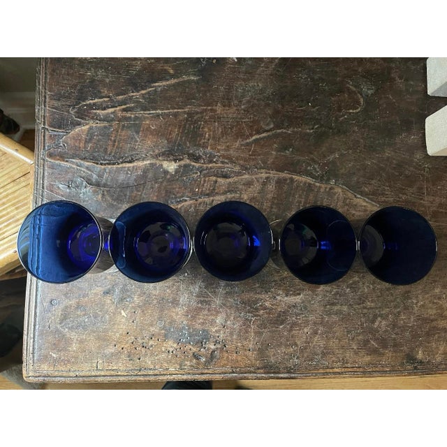 Stunning set of five wine glasses by Sasaki, in the deepest of midnight blue top on a clear stem. They hold approximately...