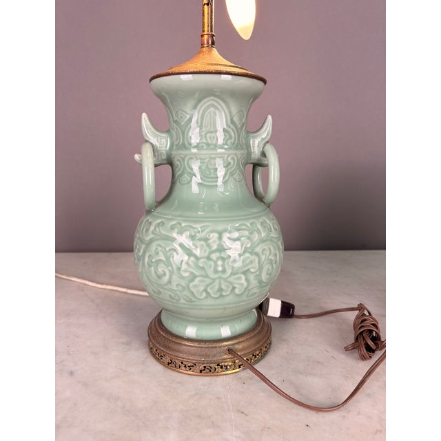 Green celadon color with ornate brass accents. Large fixed rings on both sides. Two bulb antique corded lamp in working...