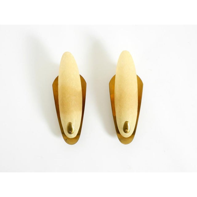 Two beautiful mid-century modern brass wall lamps with fiberglass shades. a superb, high-quality design typical of the...