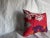 A striking antique Suzani pillow dating back to the early 1900s, hand-embroidered in rich cotton threads over a deep red...