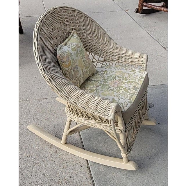 This fine child's wicker rocking chair is in fine condition and has a newly upholstered in leather with a little leather...