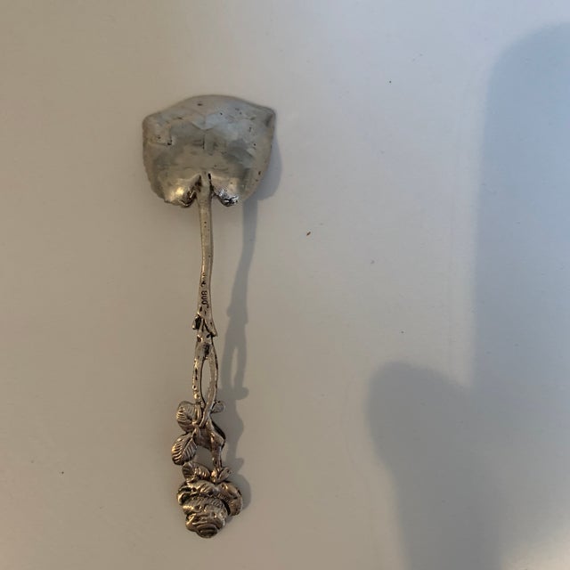 This charming small scoop probably was used for sugar. The handle is topped by a rose blossom with three of its leaves....