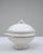 This 20th Century Belgian special edition porcelain tureen features a classic rounded silhouette elevated on a flared...