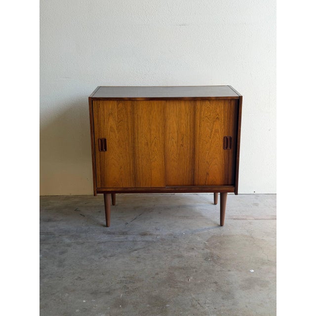 Danish Mid-Century Modern cabinet crafted in richly grained rosewood, circa 1960s. This piece features classic...