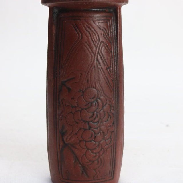 An exquisite example of Arts & Crafts pottery, this antique redware vase features an embossed grape and leaf pattern. The...