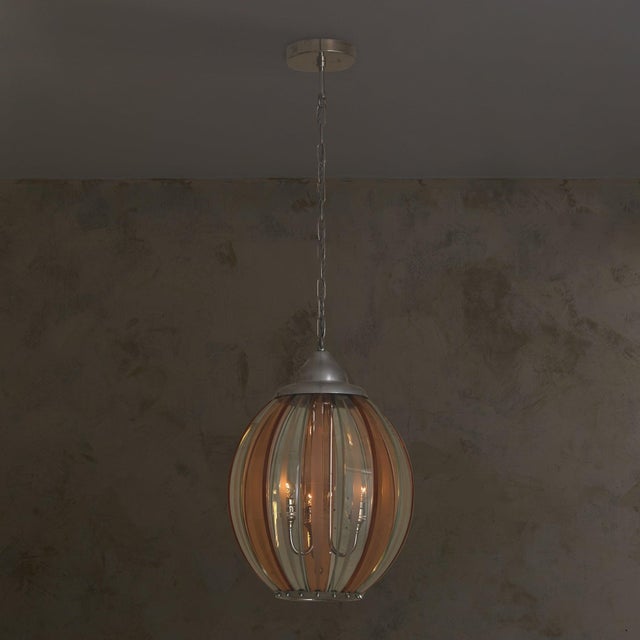 An Italian pendant from the 1970s, crafted in the manner of Veca. The lantern form is composed of alternating pink and...