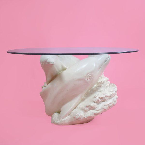 A coffee table raised on four dolphin heads — a whimsical coastal base with roots in classical grotto and Regency design....
