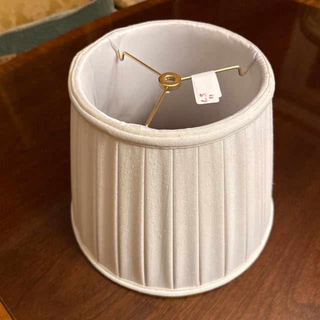 Off-white eggshell, color, linen texture, pleated lampshade. Three arm brass spider with 1/2” recess