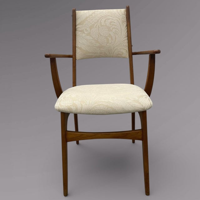 Mid century Danish modern teak arm chair with sculpted arms, tapered legs, and clean Scandinavian lines. Warm honey-toned...