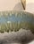 This striking hand-thrown studio pottery bowl features a beautifully layered blue-green drip glaze over a warm, earthy...
