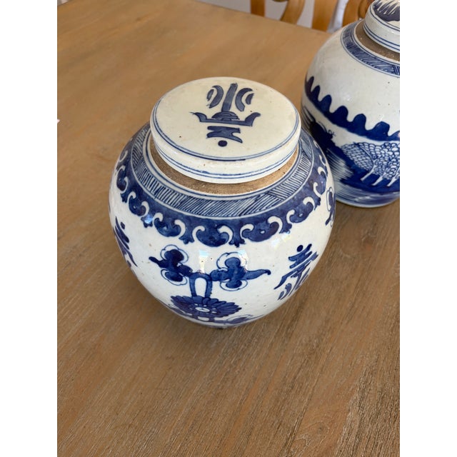 A charming pair of small ginger jars crafted in classic blue and white, featuring delicate Asian-inspired motifs. Their...