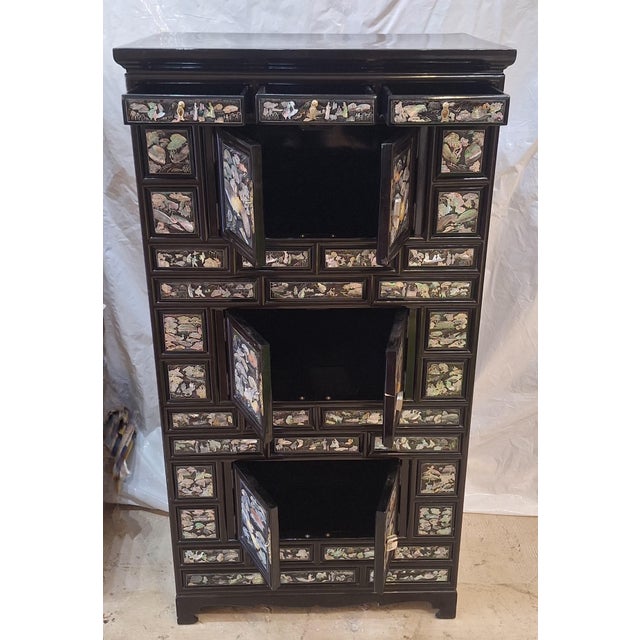 Mid 20th Century Korean lacquer cabinet is an example of traditional najeonchilgi craftsmanship, featuring extensive...