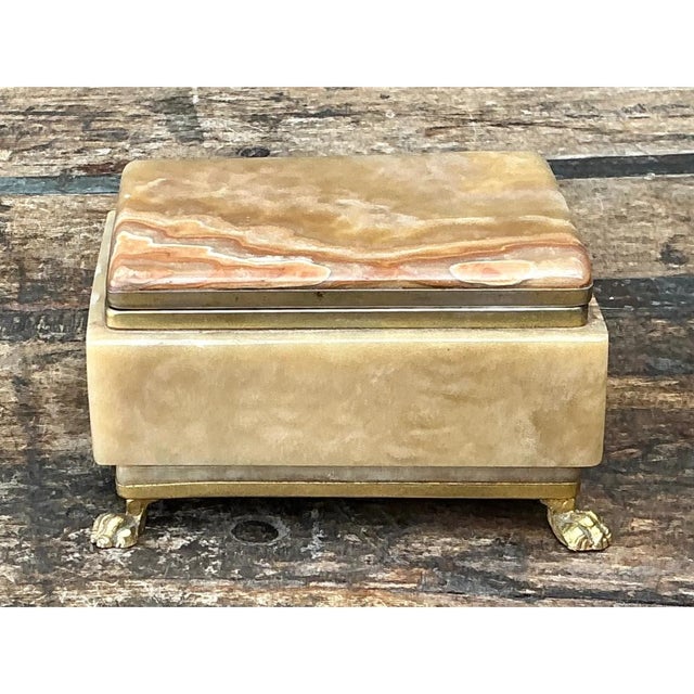 This vintage onyx and brass footed box is a striking example of decorative object craftsmanship, its rectangular form...