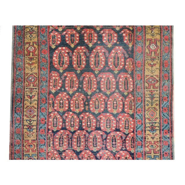A wonderful early 20th century N.W. Persian runner with an all-over paisley pattern woven in crimson, gold, light indigo,...