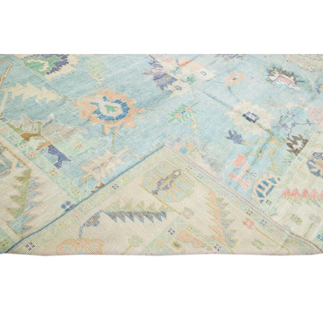 Beautiful modern Oushak hand-knotted wool rug with a blue field. This Oushak rug has beige frame multicolor accents that...