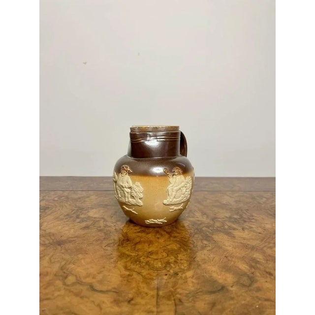 Antique Royal Doulton harvest jug, having a antique Royal Doulton harvest jug with a two tone brown ground decorated in...