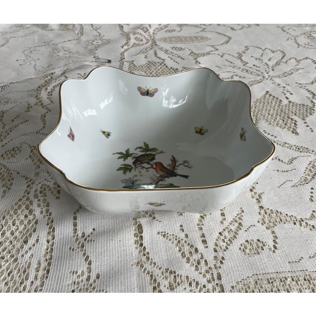 The Herend Bowl is a beautifully handpainted square piece featuring a charming robin and various insects. This exquisite...
