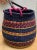 Colorful woven seagrass decor and storage basket with faux leather handles and bold mixed color pattern in deep blue,...