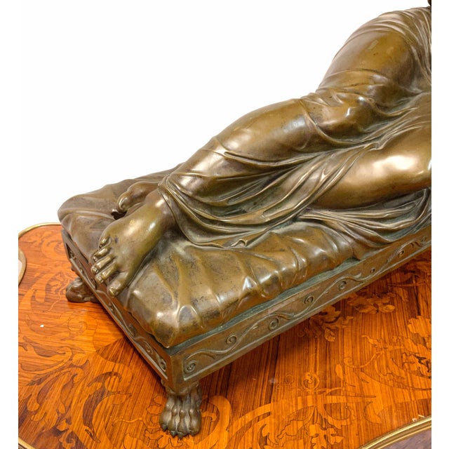A large 19th C. French Patinated Bronze sculpture of a reclining nude woman lying on a day bed. Please note the wooden...