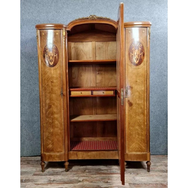 Louis xvi style marquetry armoire with a projecting front, circa 1880. the delicately curved front opens with three doors,...