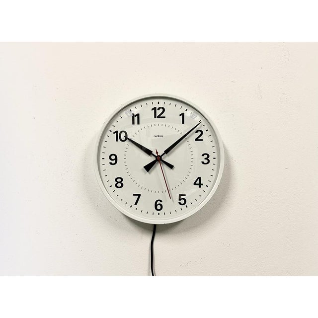 Nedklok wall clock was made in Netherlands during the 1970s. It features a white iron frame, a metal dial, an aluminium...