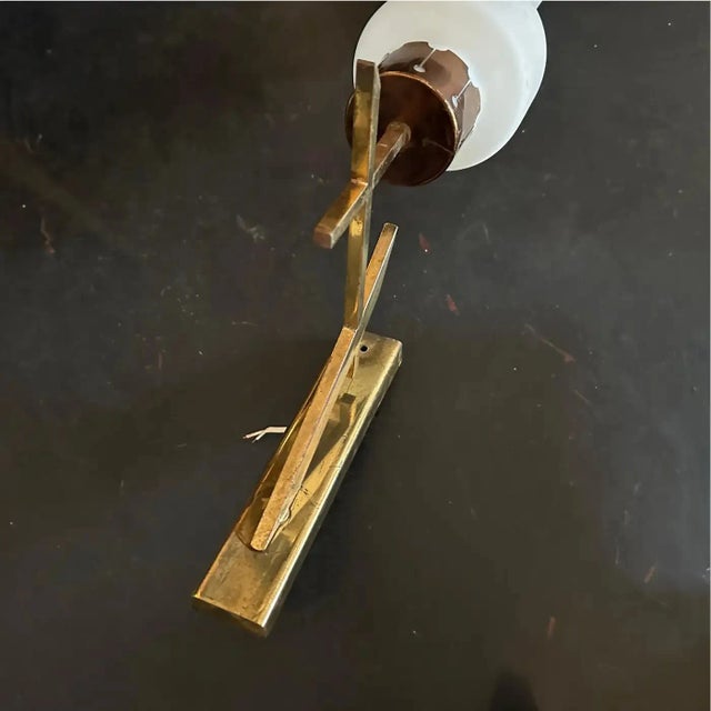 These wall sconces exhibit a classic 1950s mid-century modern aesthetic, inspired by Stilnovo's Italian designs. The...