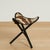 Chic safari style bench crafted with an organic zebra hide fitted on a folding tripod ebonized hardwood base.