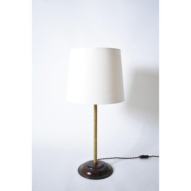 Brass and wood viennese secession lamp, 1910s. Viennese secession table lamp resting on a wooden base, with an ornamental...