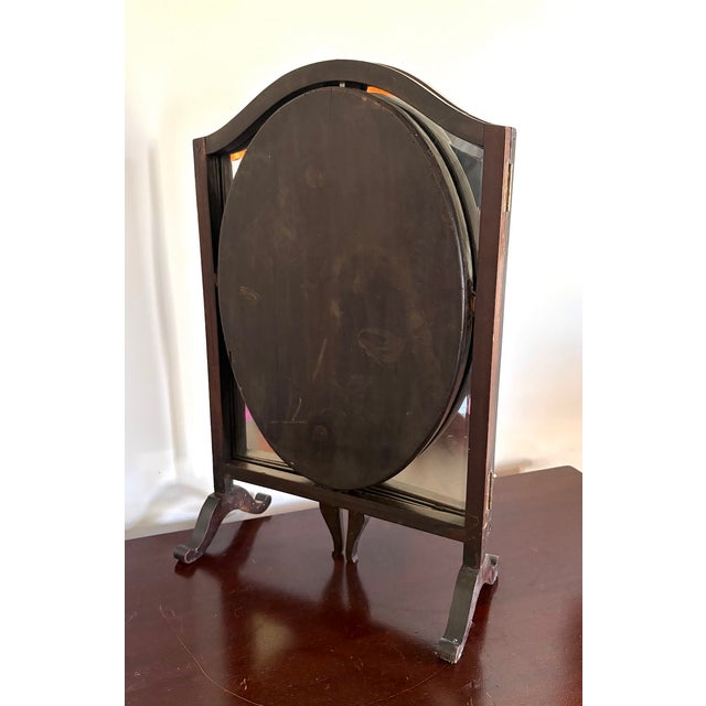 Early 1900s mahogany trifold tabletop/vanity mirror. Center oval mirror swivels/pivots. One small chip in wood near upper...