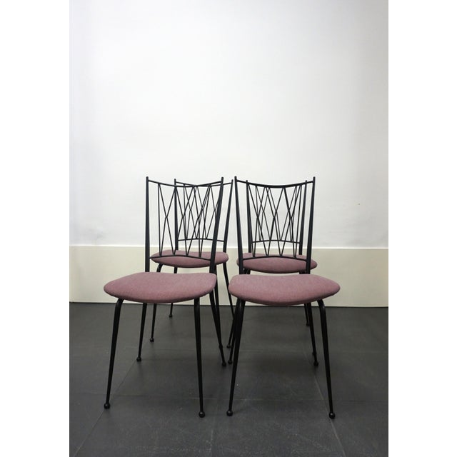 Set of four French dining chairs from the 1950s, design attributed to Colette Gueden. Black lacquered metal frame and...