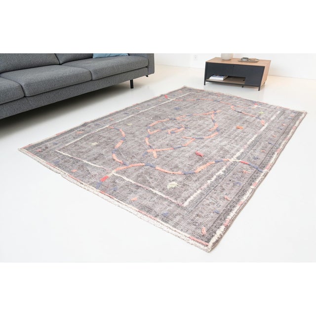 This is a vintage Turkish Oushak rug from the Mid 20th Century. The piece was hand-knotted.