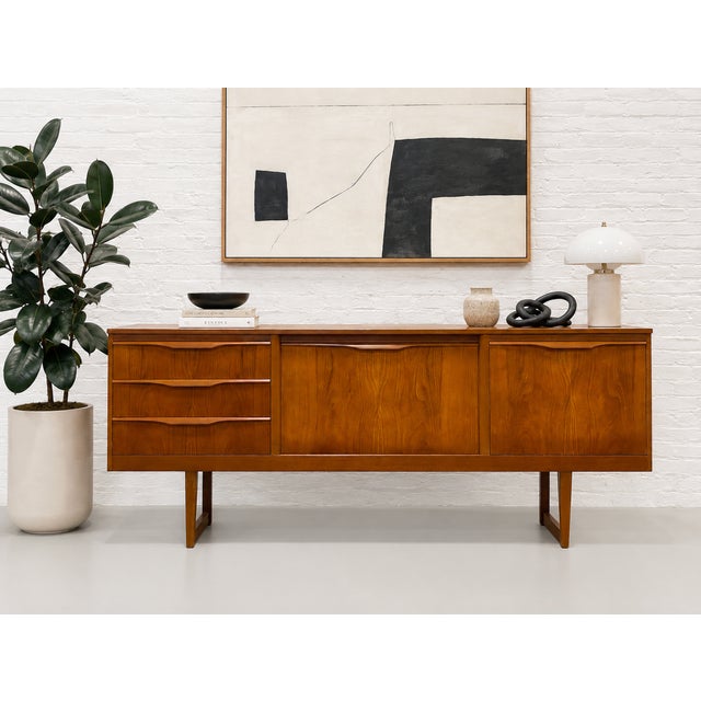 Mid Century Modern Teak Credenza featuring warm teak wood grain, sculpted integrated drawer pulls, clean architectural...