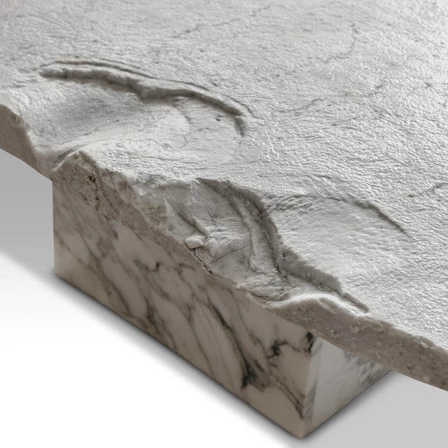 Unique sculptural coffee table. Made of a discarded irregular carrara marble top and arabescato base, hand polished. A...