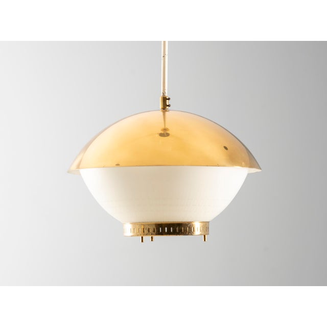 This large vintage pendant light features a refined combination of brass and engraved opaline glass. Its balanced...