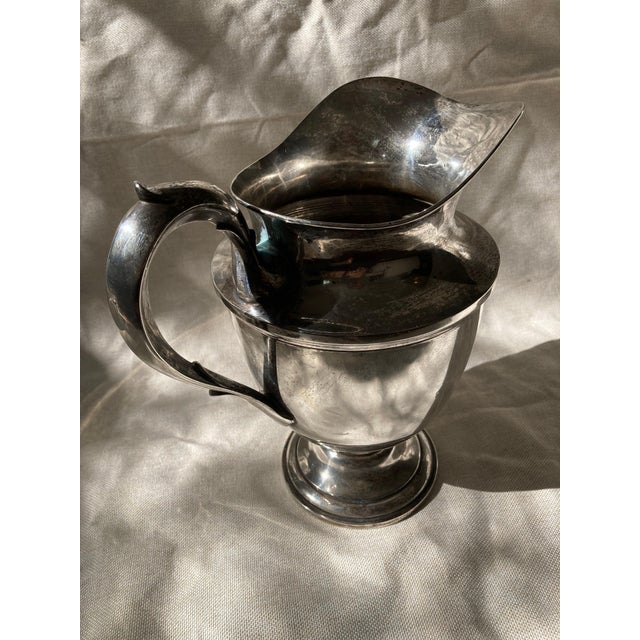 An elegant and substantial American sterling silver water pitcher by the distinguished Whiting Manufacturing Company,...